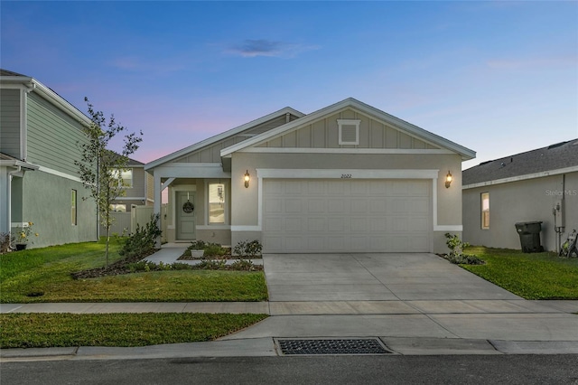 view of front of property featuring concrete driveway, a front lawn, board and batten siding, and an attached garage