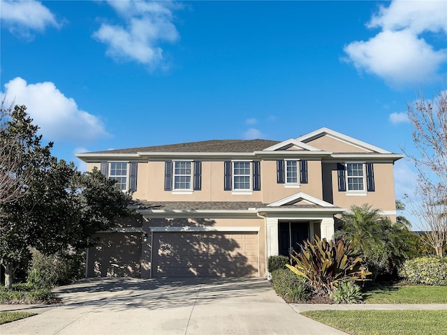 view of front facade featuring driveway, an attached garage, and stucco siding