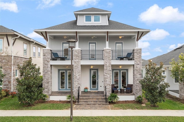 view of front of home with french doors, a shingled roof, a balcony, and a ceiling fan