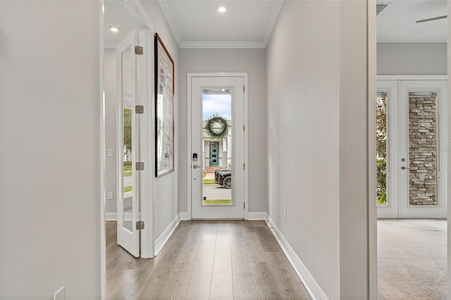 entrance foyer with light wood finished floors, visible vents, baseboards, and crown molding