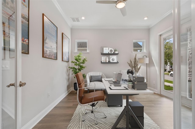 office featuring baseboards, wood finished floors, visible vents, and crown molding