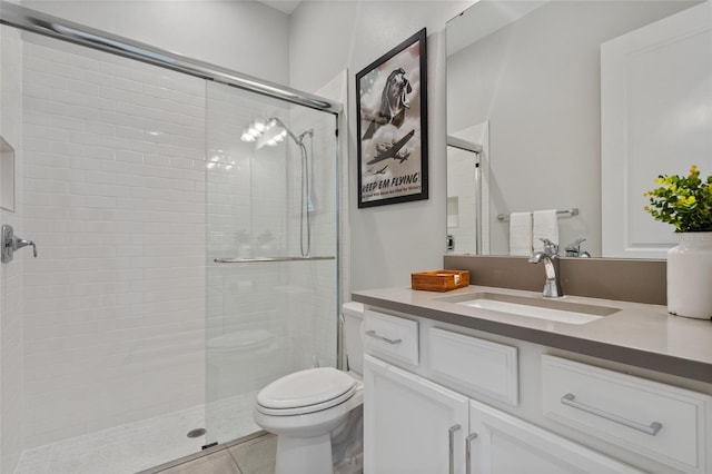 full bath with tiled shower, vanity, toilet, and tile patterned floors