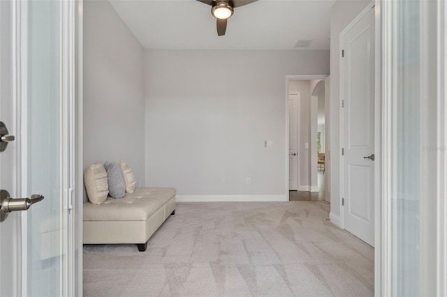 living area with baseboards, visible vents, arched walkways, a ceiling fan, and carpet floors