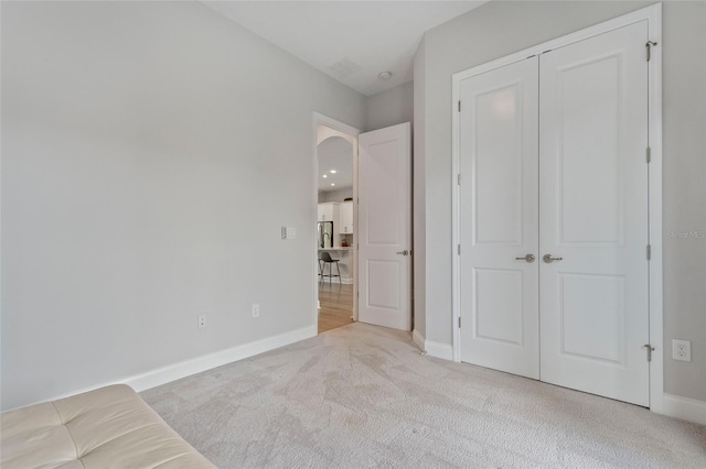 unfurnished bedroom with a closet, carpet flooring, and baseboards