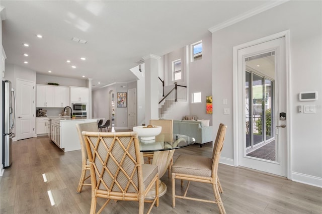 dining area with baseboards, stairway, crown molding, light wood-style floors, and recessed lighting