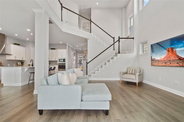 living room with stairway, recessed lighting, light wood-style flooring, and baseboards