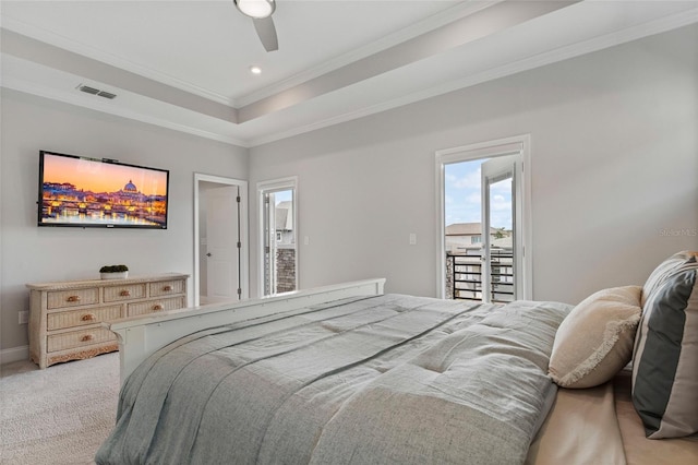 bedroom with a tray ceiling, crown molding, visible vents, light carpet, and ceiling fan