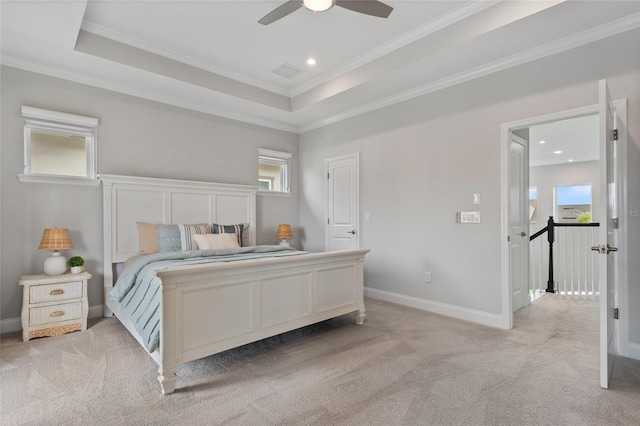 bedroom featuring light carpet, baseboards, a raised ceiling, and crown molding