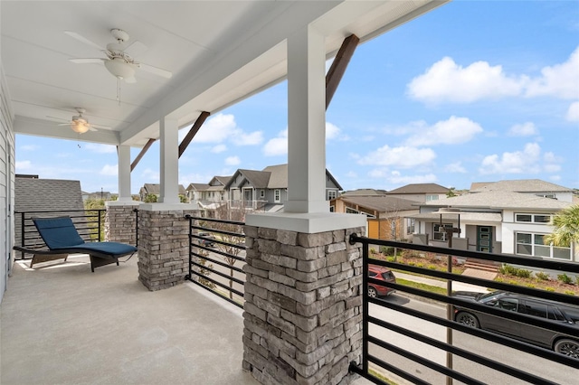 view of patio / terrace featuring ceiling fan, a residential view, and a balcony