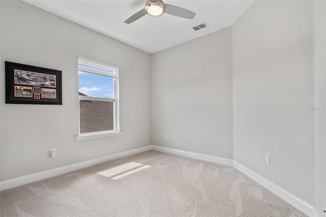 unfurnished room featuring a ceiling fan, light colored carpet, visible vents, and baseboards