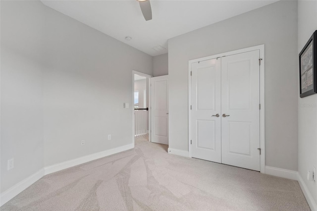 unfurnished bedroom featuring carpet floors, ceiling fan, baseboards, and a closet