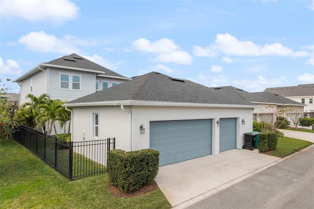 view of home's exterior featuring roof with shingles, a yard, concrete driveway, fence, and a garage