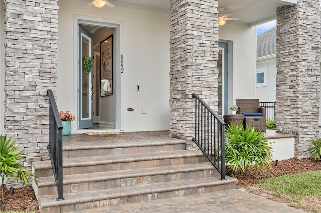 view of exterior entry featuring covered porch, stone siding, and stucco siding