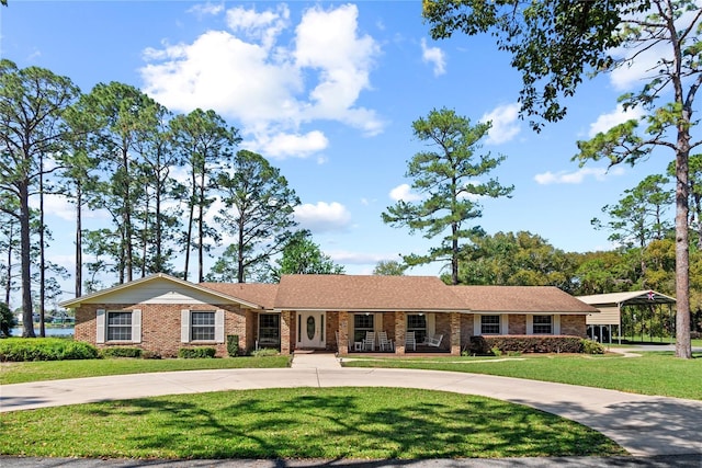 ranch-style home featuring a front lawn, concrete driveway, and brick siding