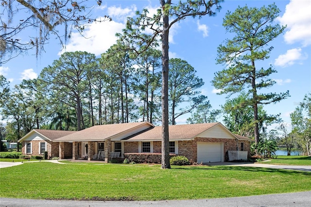 ranch-style home featuring a garage, driveway, a front lawn, and brick siding