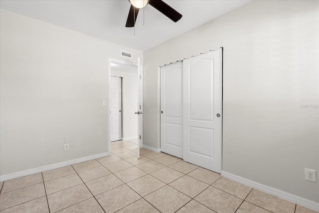 unfurnished bedroom with a ceiling fan, visible vents, baseboards, and light tile patterned floors