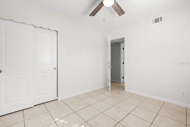 unfurnished bedroom with baseboards, visible vents, a ceiling fan, and light tile patterned flooring