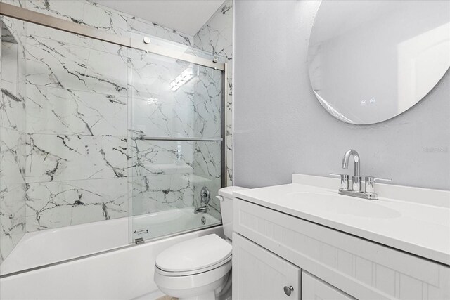 full bath with toilet, shower / bath combination with glass door, and vanity