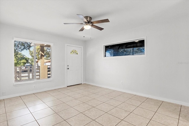 empty room featuring ceiling fan and baseboards