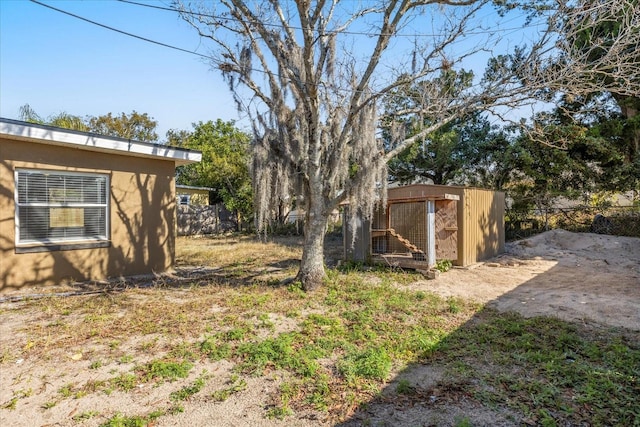 view of yard featuring fence and an outbuilding