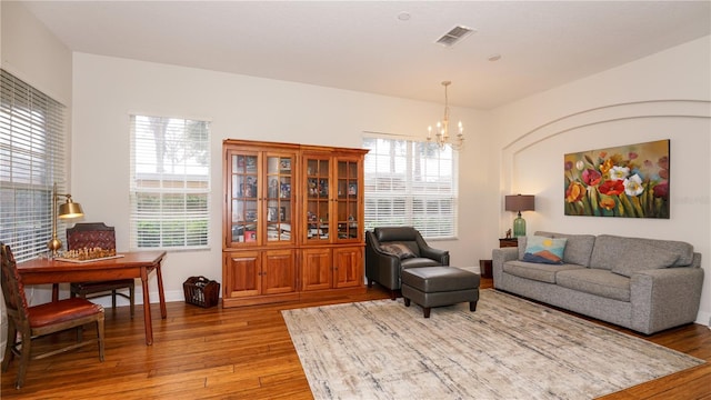 living room featuring light hardwood / wood-style flooring, a chandelier, and a wealth of natural light