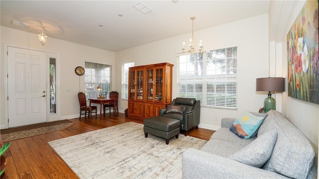 living room featuring a chandelier, a wealth of natural light, and hardwood / wood-style floors