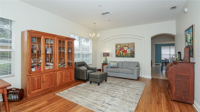 sitting room with hardwood / wood-style floors and a chandelier