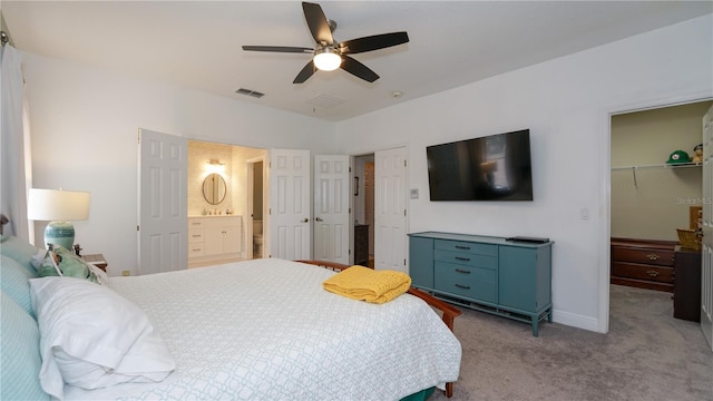 carpeted bedroom with ceiling fan, a closet, a walk in closet, and ensuite bath