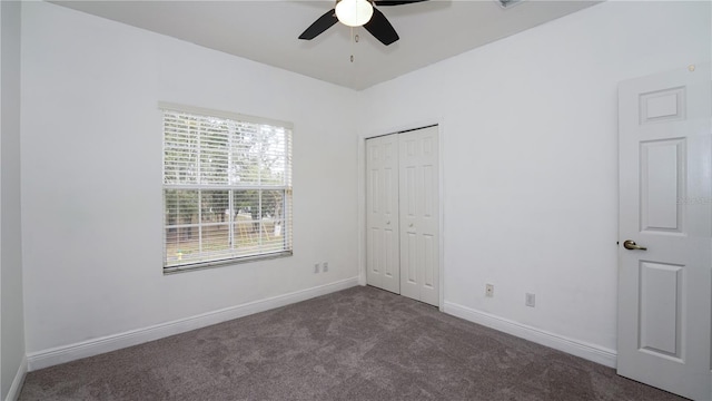 unfurnished bedroom featuring dark carpet, ceiling fan, and a closet