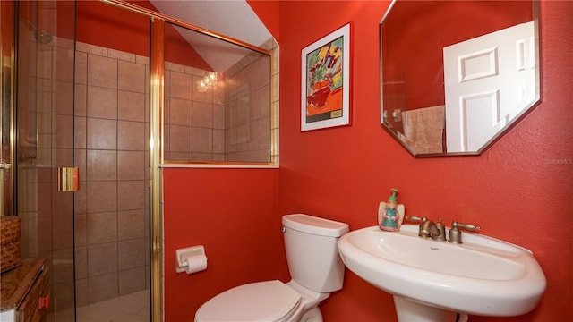 bathroom featuring sink, an enclosed shower, and toilet