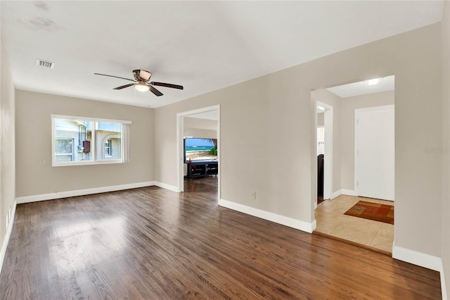 unfurnished room featuring dark wood-type flooring and ceiling fan