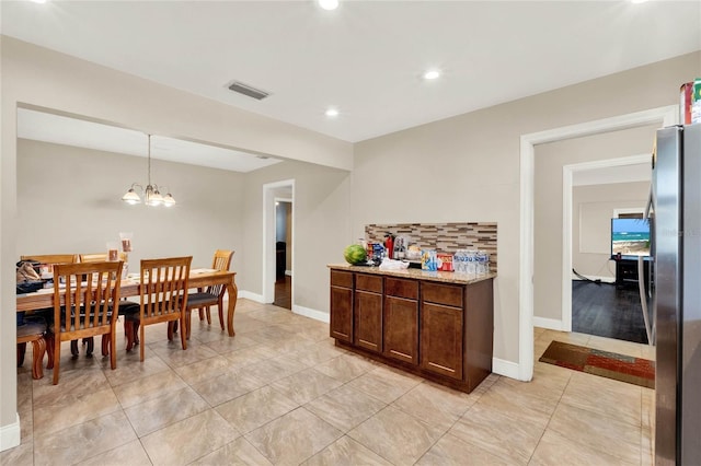 tiled dining area featuring a notable chandelier