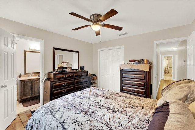 bedroom with ceiling fan, light wood-type flooring, connected bathroom, and a closet