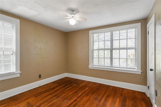 spare room with ceiling fan, a textured ceiling, baseboards, and wood finished floors