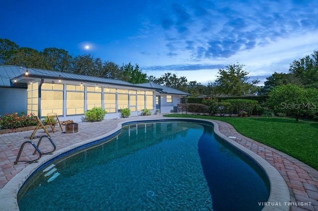 outdoor pool featuring a patio area and a lawn