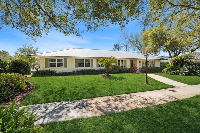 single story home with a front lawn and metal roof