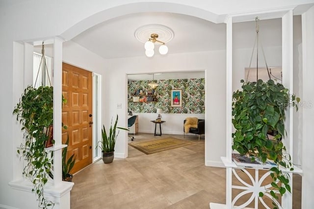 entrance foyer featuring baseboards and arched walkways