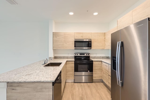 1209 S Station Pl Unit 306, Orlando, FL 32809 - kitchen featuring modern cabinets, appliances with stainless steel finishes, light stone countertops, light brown cabinetry, and a sink