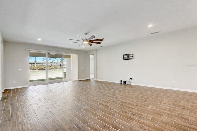 unfurnished room with light wood finished floors, visible vents, baseboards, ceiling fan, and a textured ceiling