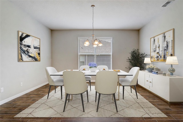 dining room featuring baseboards, visible vents, a textured ceiling, wood finish floors, and a chandelier