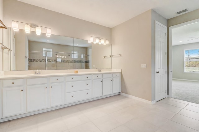 full bath featuring double vanity, a stall shower, a sink, and visible vents