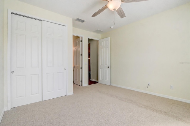 unfurnished bedroom featuring light carpet, baseboards, visible vents, ceiling fan, and a closet