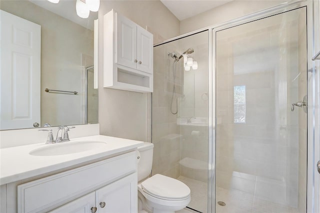 bathroom featuring a stall shower, vanity, and toilet