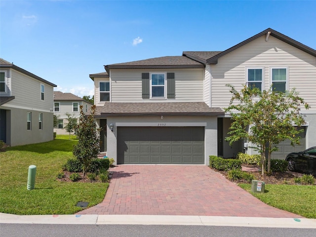 2052 Milkweed St, Ocoee, FL 34761 - view of front facade featuring an attached garage, a front yard, decorative driveway, and roof with shingles
