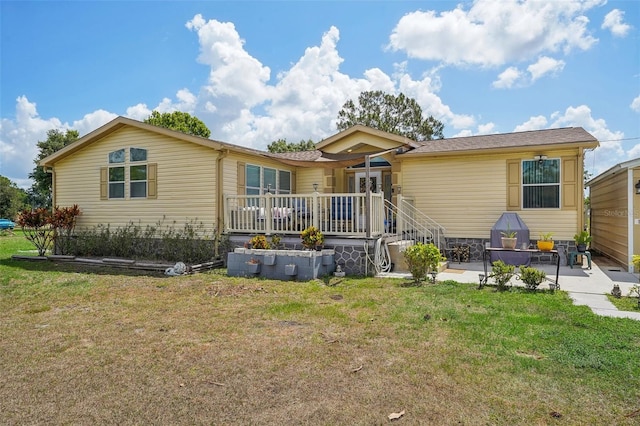 back of property featuring a deck, stairway, a lawn, and a patio area