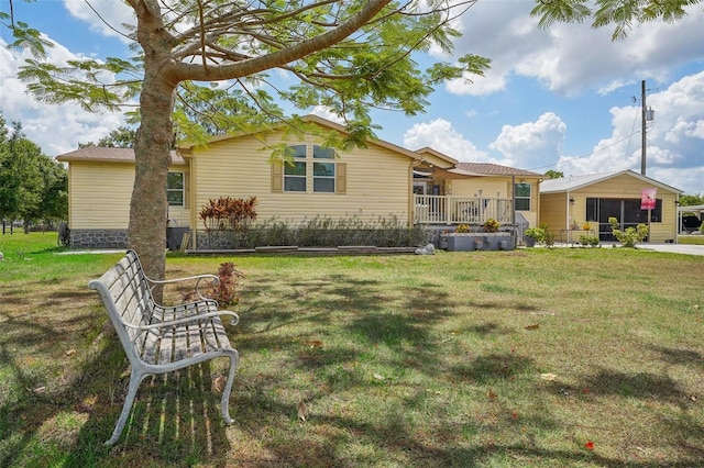 rear view of house featuring a porch and a lawn