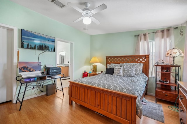 bedroom featuring light wood-style floors, ceiling fan, visible vents, and baseboards