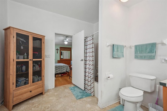 ensuite bathroom featuring shower / bath combo, baseboards, connected bathroom, toilet, and vanity