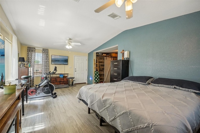 bedroom featuring visible vents, vaulted ceiling, light wood-style flooring, and ceiling fan