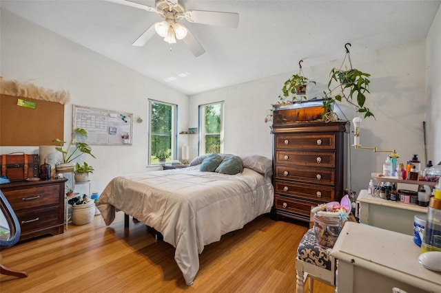 bedroom with vaulted ceiling, light wood-type flooring, and a ceiling fan